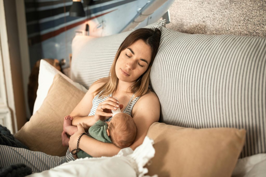 tired mum feeding baby